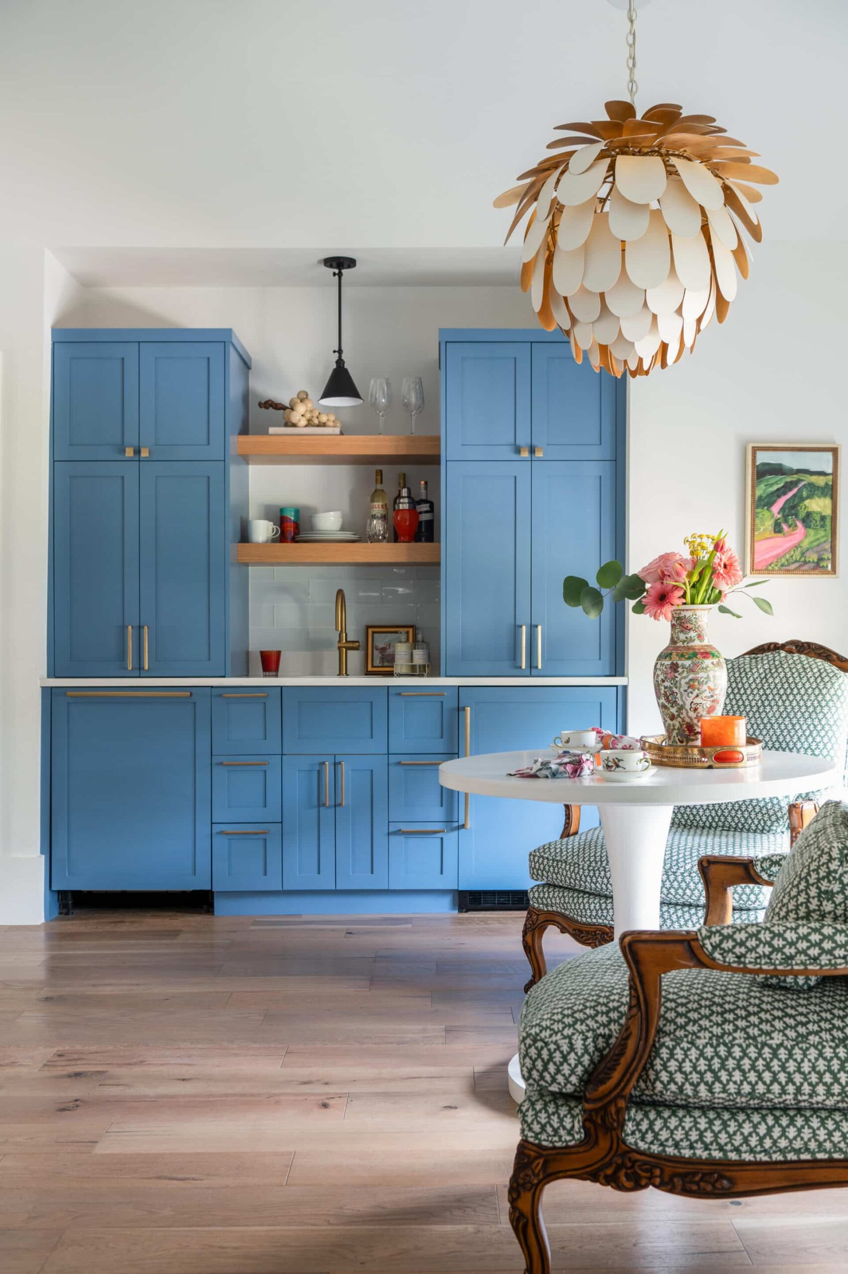 Blue built-in cabinetry with open shelving styled with ceramics and greenery