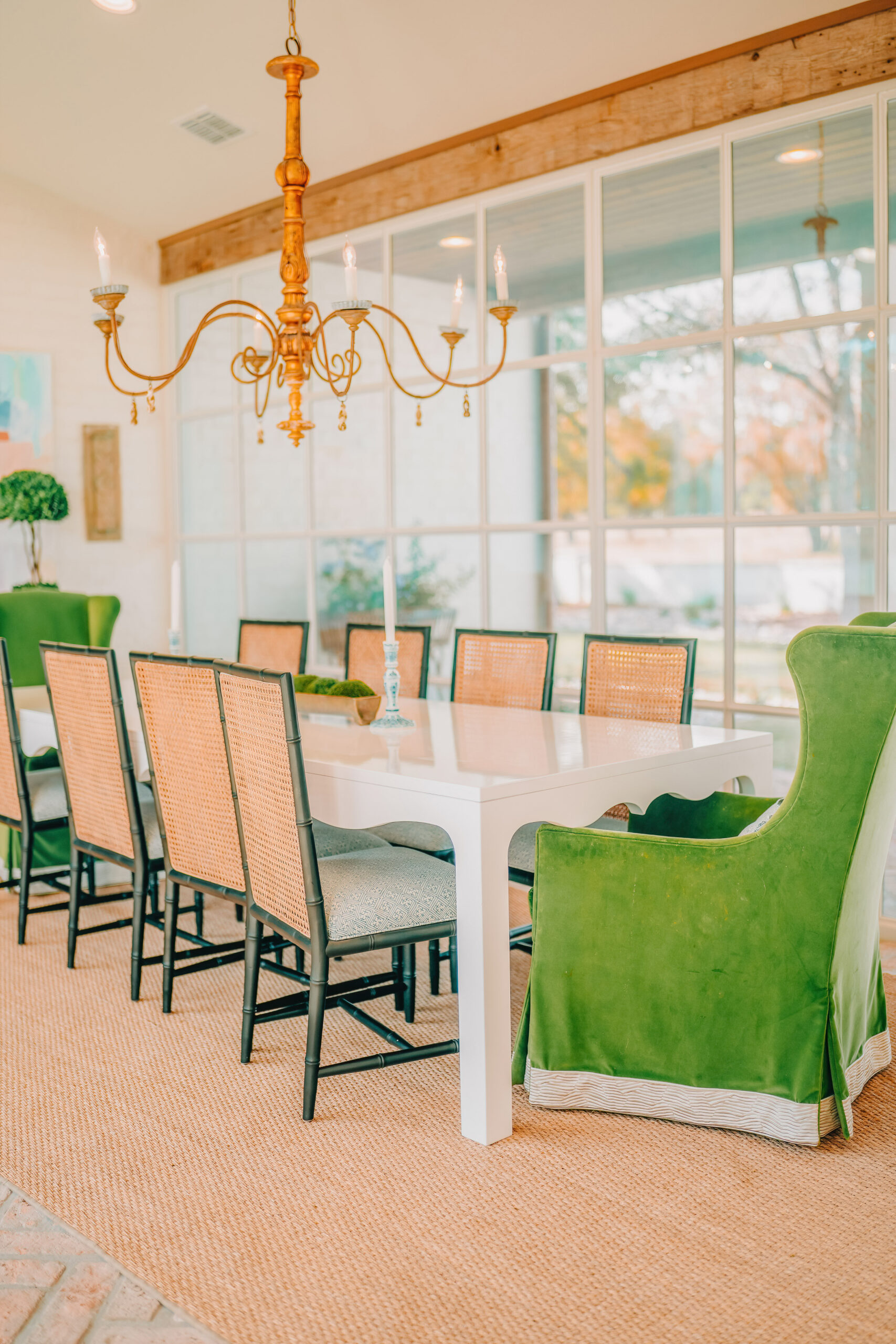 Dining room with green upholstered chairs beneath a gilt chandelier